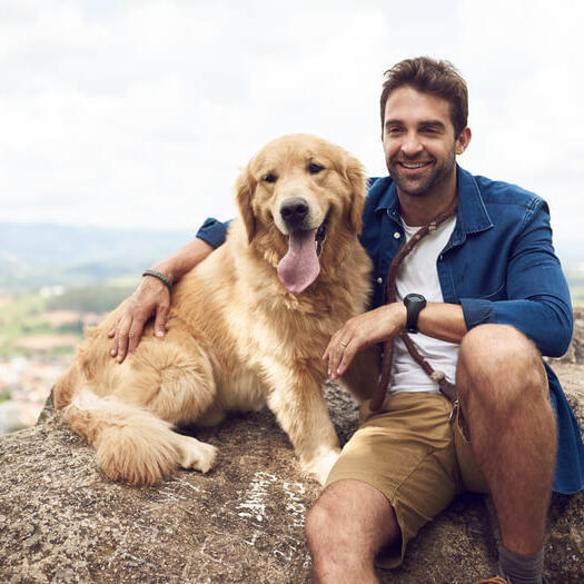 Man met golden retriever op de rots