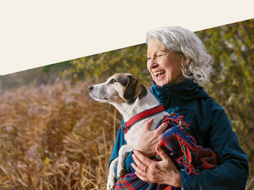 Oudere dame die haar hond vasthoudt