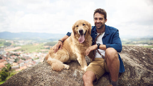 Homme avec golden retriever sur le rocher