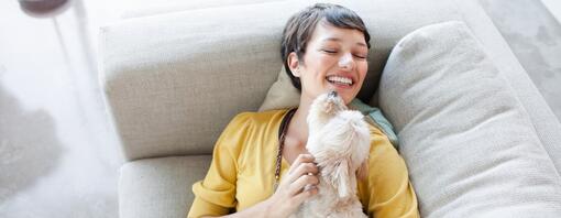 Woman smiling and hugging a dog – hero